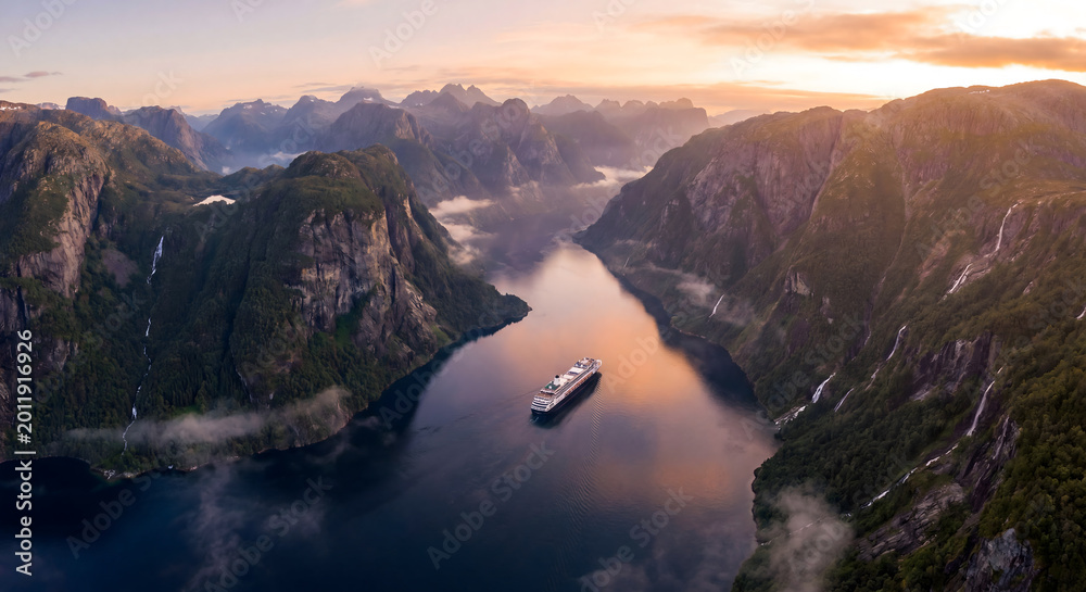 Fototapeta premium Cruise ship sailing through a dramatic Norwegian fjord at golden hour