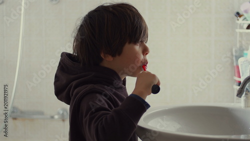 Foto Child brushing teeth at bathroom sink with focus and concentration, daily hygien