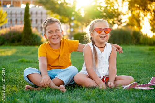 little children flying a plane, a boy and a girl playing with a plane on a green lawn, laughing children on the grass in summer, summer holidays