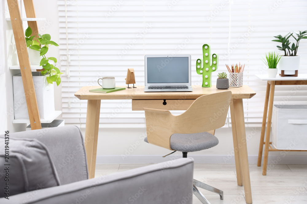 Fototapeta premium Stylish workplace with laptop and stationery in child's room