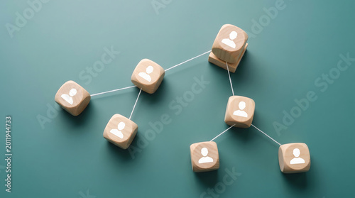 Wooden blocks with human icons connected by lines on green background