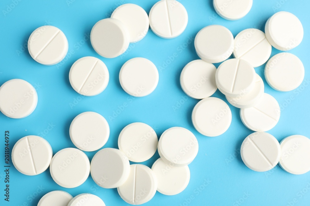 Obraz premium Many pills on light blue background, flat lay