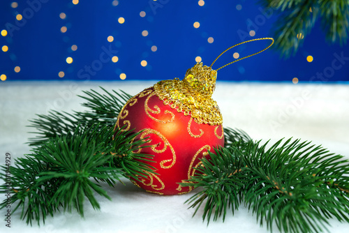Large red ball with Christmas tree branches on a white background