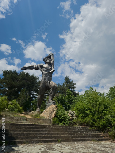 Canvas Print statue of a man monumental headstrong man above stairs with sunny sky