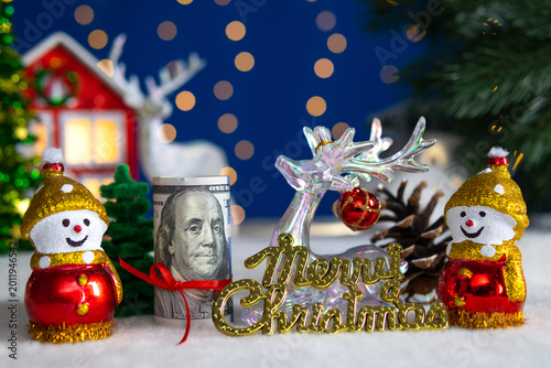 Between two snowmen is a dollar bill with a deer and letters