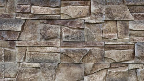 Bilde på lerret Wall decoration with square stone tiles of various sizes in grey-brown colour wi