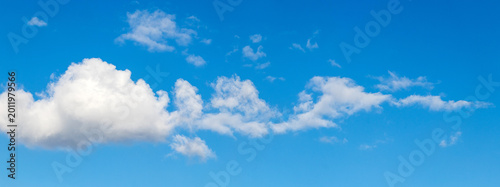 Photography Bright blue sky with fluffy white clouds along the bottom of the frame, sunny su