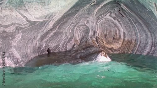 Gaze upon the mesmerizing Marble Caves in Patagonia, where pristine azure waters gently ripple against swirling, sculpted rock formations. A testament to nature's profound artistry.