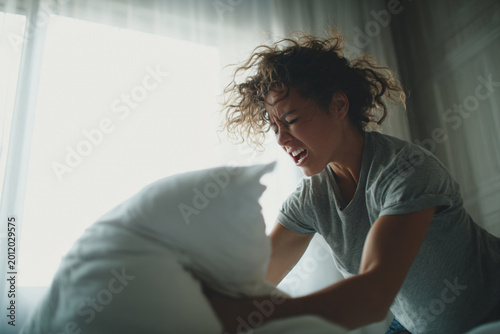 somatic anger release, woman punching pillow at home and screaming, emotional release of rage