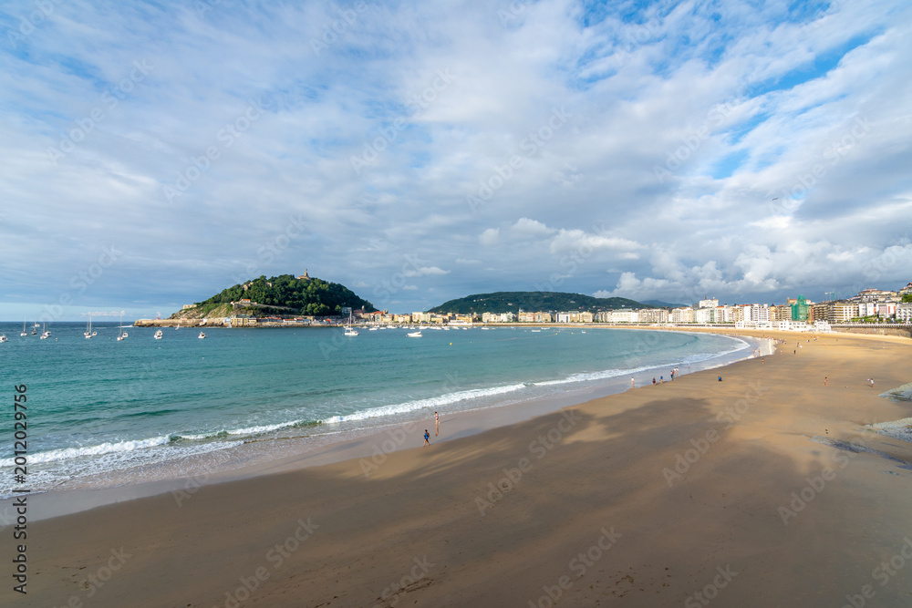 Obraz premium Wide panoramic view of La Concha beach with turquoise water, coastline and Santa Clara island in San Sebastian, Basque Country, Spain.