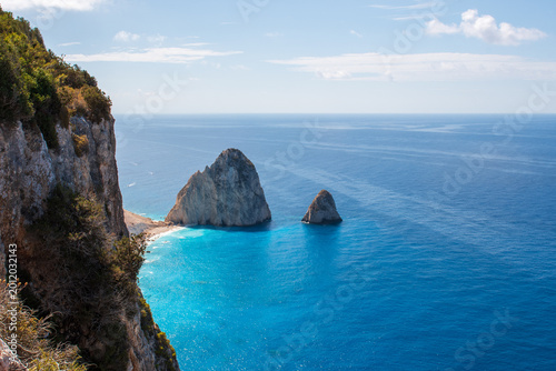 Tableau sur toile Dramatic limestone cliffs overlook crystal-clear Ionian Sea with offshore rock formations and sunlit turquoise water, Zakynthos island, Greece
