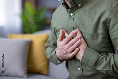 Принти на полотні Man experiencing severe chest pain and discomfort, holding his hand over his che