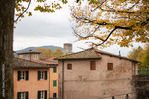 Edificio medievale con alberi autunnali a Lucca, Toscana, Italia