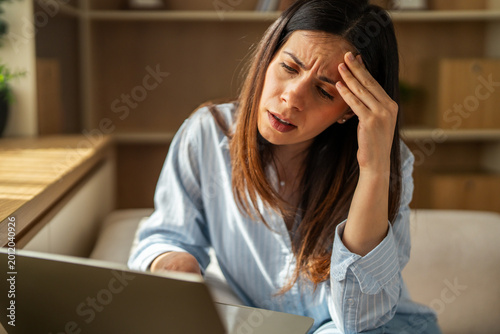 Obraz na plátně Woman experiencing stress, headache while working from home