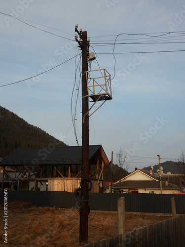 Old wooden pole supporting multiple communication lines for internet, radio, and telephone services