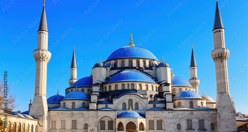 Fototapeta premium Majestic blue domes minarets a mosque shine under a clear blue sky. 