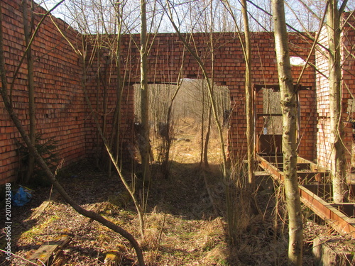 Remains of a brick narrow-gauge railway depot crumbling over time and reclaimed by nature