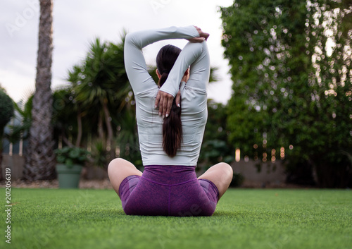 Foto Woman stretching arms behind back practicing yoga outdoors mindfulness