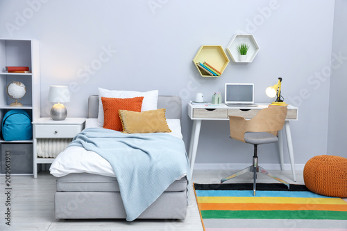 Cuadro en lienzo Comfortable bed and stylish workplace in child's room