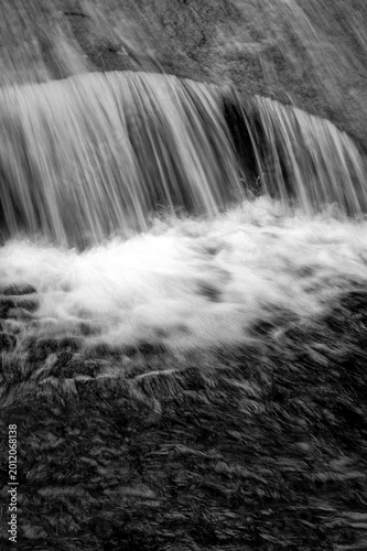 Abstract black and white long exposure of rushing waterfall and flowing water