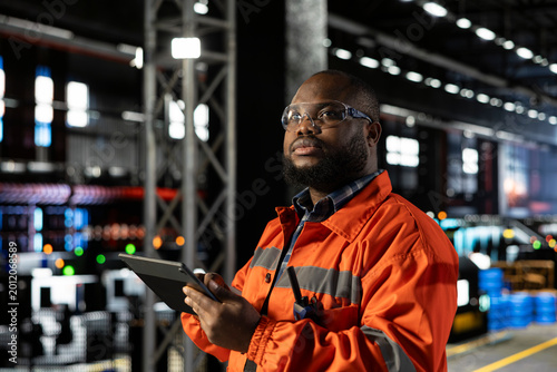 Fotografie Engineer in safety glasses using tools in a fabrication workshop, showing manufacturing process focus, manpower strength and the industrial environment guiding heavy product development