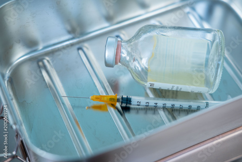 Photos syringe and empty vial on clinical surface, end life decision, ethical dilemma e