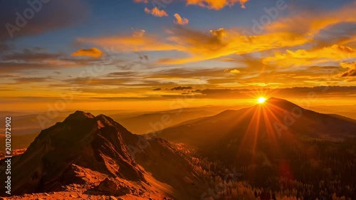 Time lapse panoramic view of sun rising over mountain ridge at sunrise