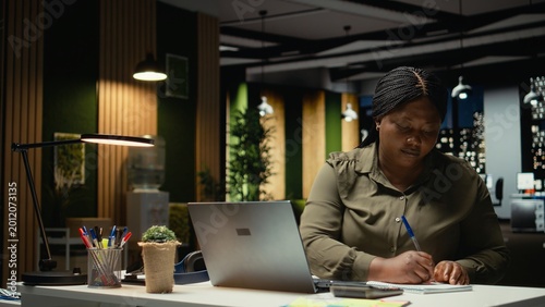 Cuadro en lienzo Mad black entrepreneur ripping paper after transcribing key points on notebook after hours, makes a writing mistake and breaks the page from the textbook