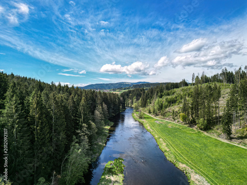 Aerial view of Regen river flowing through forest landscape near Regen town in Bavarian countryside
