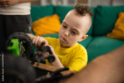 Photos Boy concentrating on repairing toy rc vehicle