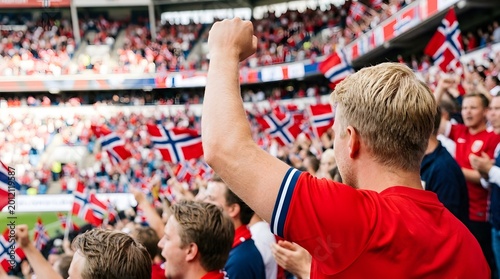 Passionate Norwegian soccer fan celebrating victory at a stadium with national flags in background.