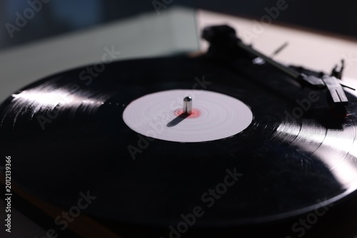 Modern turntable with vinyl record on white table , closeup