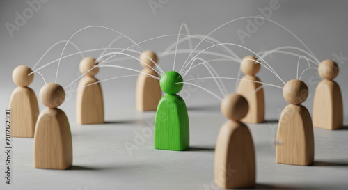Networked Leadership: A Green Figure Standing Out Among Wooden Figures in a Social Connection Concept on a Gray Background