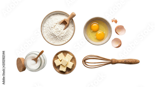 Baking ingredients flat lay on white background, flour and eggs in ceramic bowls, butter cubes and sugar jar with wooden whisk for recipe concept