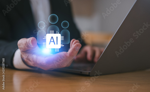 Business man hand holding ai icon and people pegs and using computer laptop working with AI technology for Human Resources recruitment program. using ai tech as an assistant at work.
