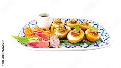 Fotografie Authentic Thai son-in-law eggs featuring crispy fried eggs and rich tamarind glaze, garnished with chili and fried shallots on white background