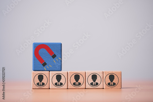 Customer attraction and lead generation concept with magnet icon above business people blocks, representing recruitment, marketing strategy, talent acquisition and audience targeting