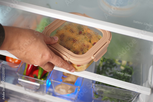 Schilderij op canvas Reaching for food storage in refrigerator during meal prep