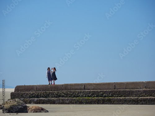 夏の愛知県の知多半島の内海海岸で遊んでいる子供姉妹の姿