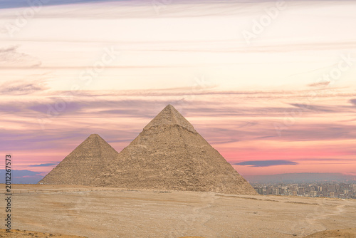 Foto The Great Pyramids of Giza rise against a vivid Egyptian sunset, evoking millennia of history and culture while drawing travelers to one of Africas most iconic archaeological