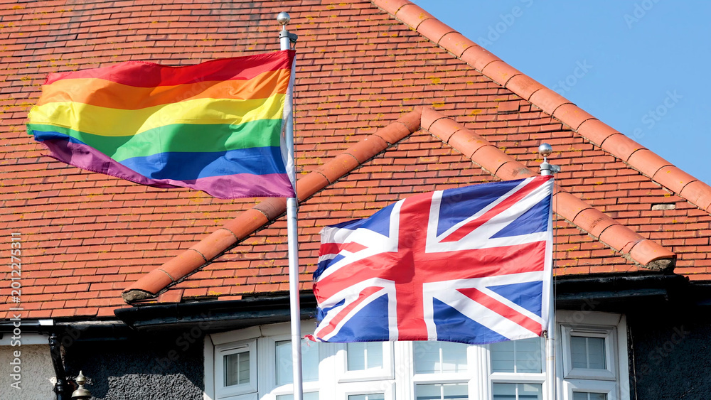 Obraz premium Rainbow Pride Flag and Union Jack Flying Together in Brighton England