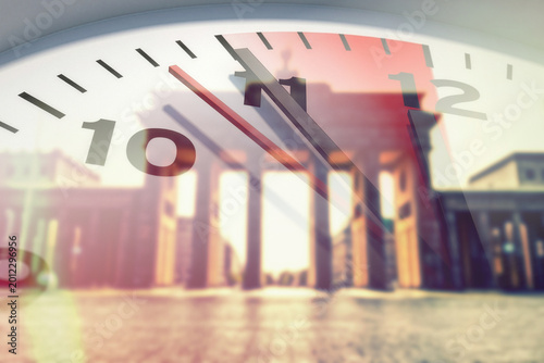 Brandenburger Tor in Berlin und eine Uhr, die 5 vor 12 zeigt und auf die Dringlichkeit der Reformen und Veränderungen hinweist