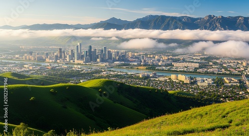 City skyline over green hills and foggy mountains