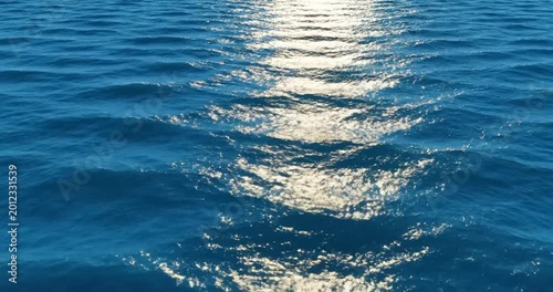 Serene ocean waves reflecting sunlight, creating a tranquil atmosphere at sea