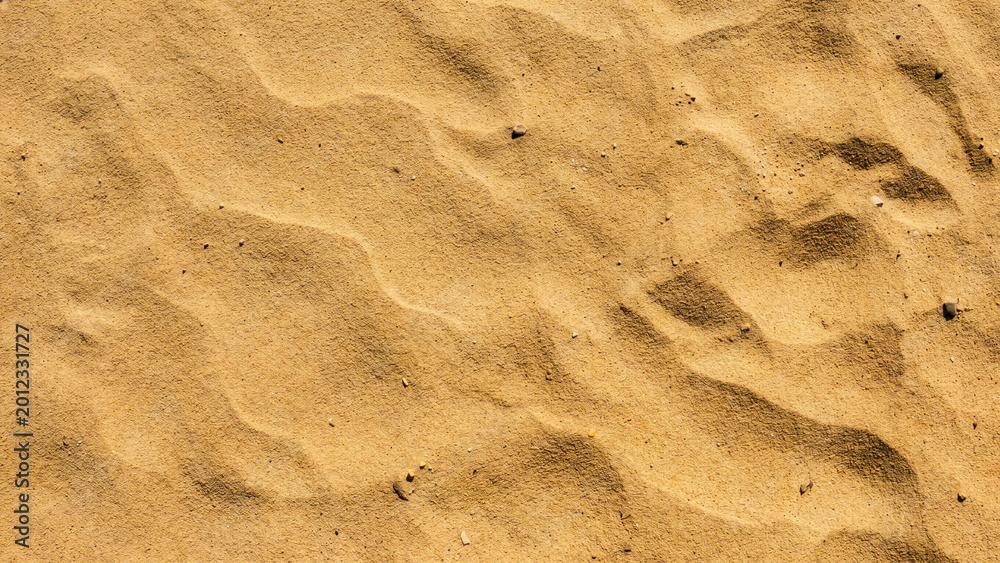 Fototapeta premium Golden Sandy Beach or Desert Surface Texture With Ripple Pattern and Small Pebbles — Top View Natural Background