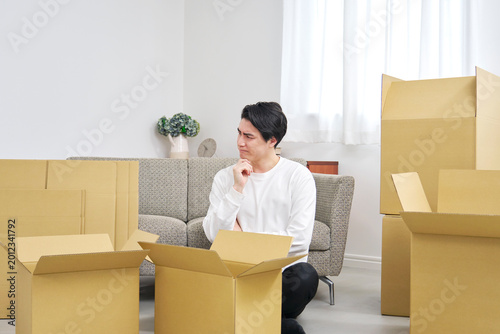 引越しの荷造り中に考える男性