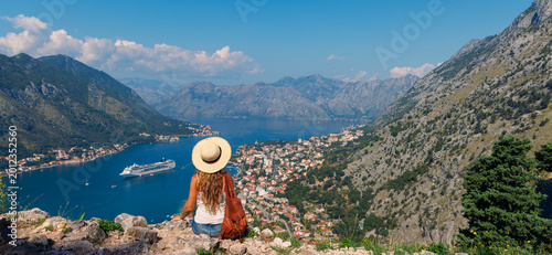 woman traveler looking at the bay of kotor and cruise ship in montenegro