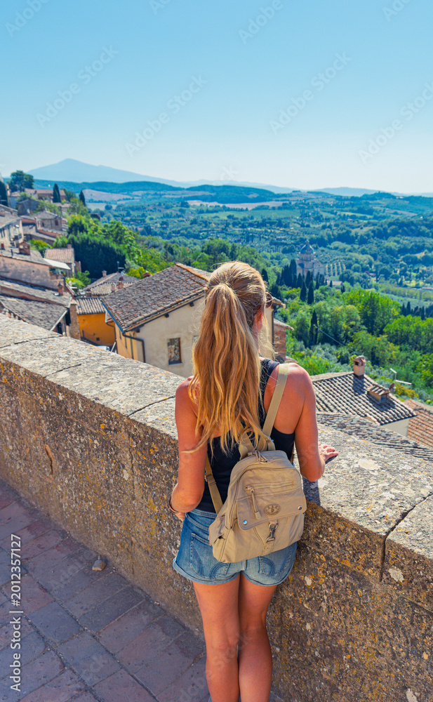 Obraz premium young woman traveler contemplating the timeless panorama of montepulciano