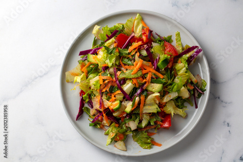 Foto Fresh Mixed Garden Salad with Red Cabbage Grated Carrots and Lettuce on a White