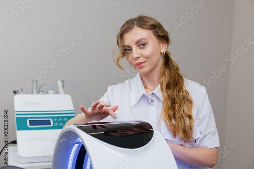 Beautician using led light therapy machine for skin rejuvenation